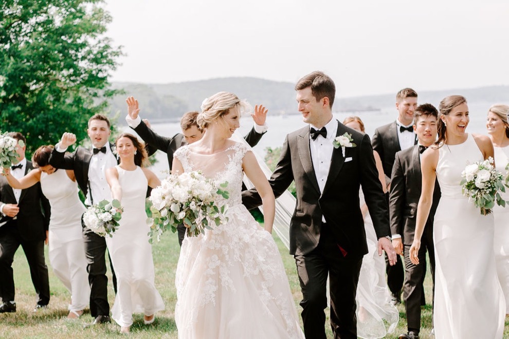 bride and groom walk happily with bridal party