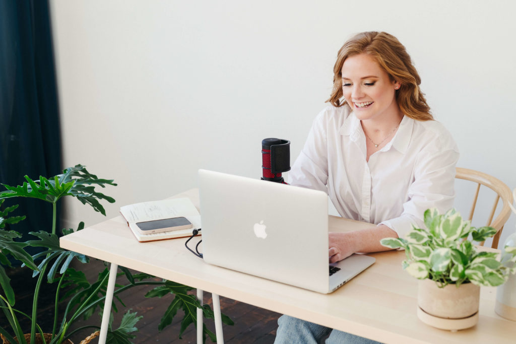 Woman business owner smiling on laptop planning business finances